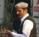 A man wearing the Afghan hat known as a pakol, right, speaks in the streets of Delhi's Little Kabul.