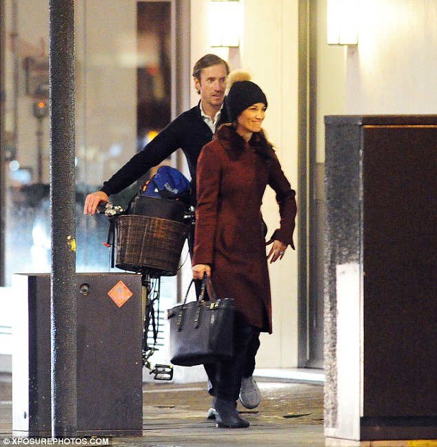 Pippa styled herself in a maroon coat and beanie whilst James was left to push her vintage bicycle