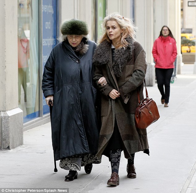 Two's company: Elena wore a furry hat and black and white patterned dress teamed with patent black shoes, while her daughter sported patterned socks and brown lace up shoes