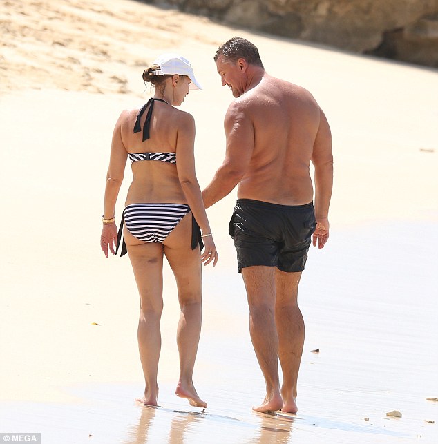 Romantic stroll: Elke, who shares sons Jake and Luke with Craig, cut a glamorous figure in a striped bikini and white sun hat