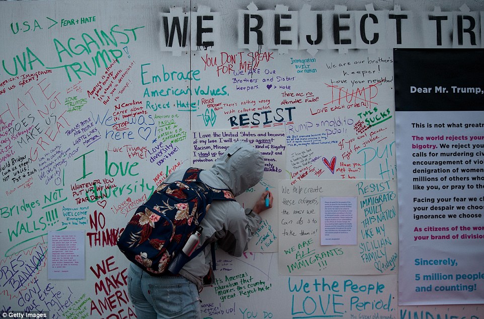 Protestors write 'messages of resistance' to President Donald Trump  on a wall near the Washington Monument