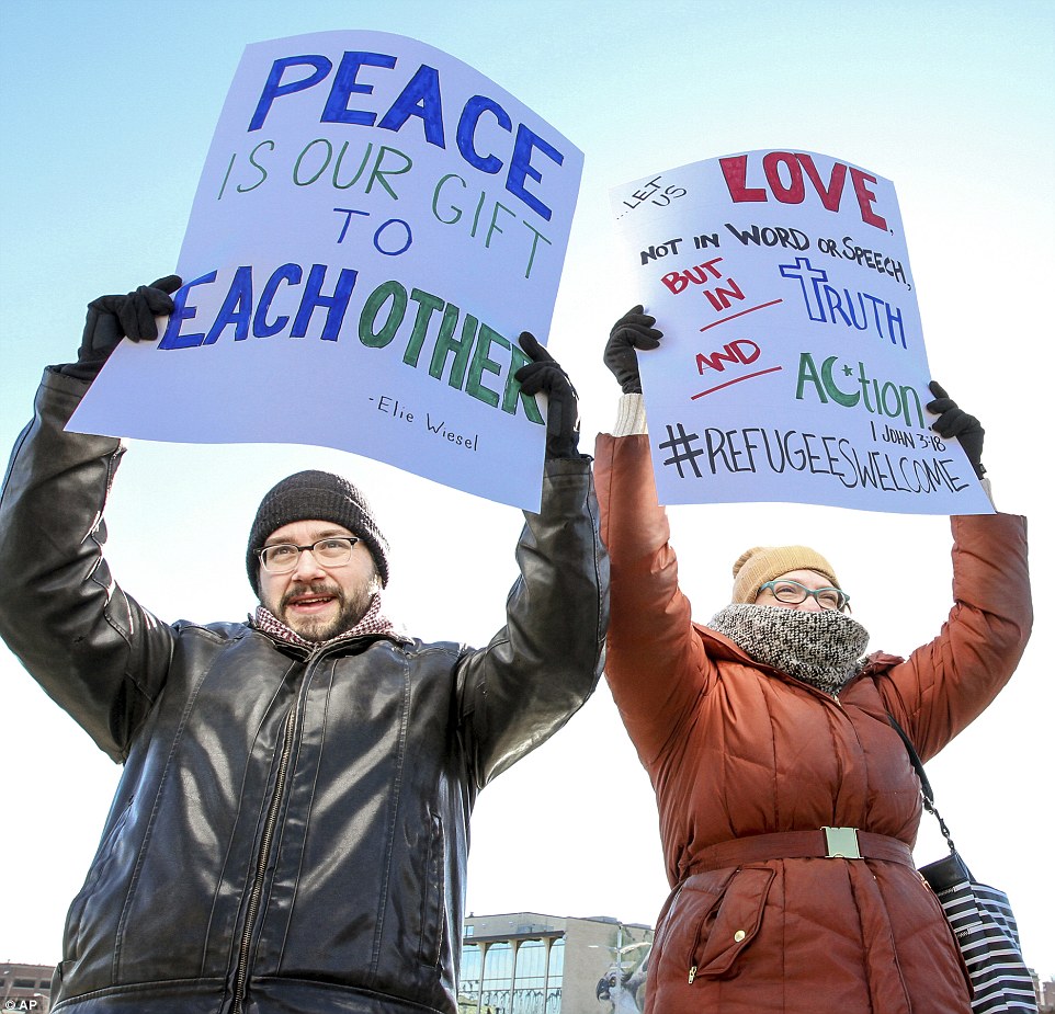 Two demonstrators hold pro-refugee signs in Owensboro, Kentucky at a rally