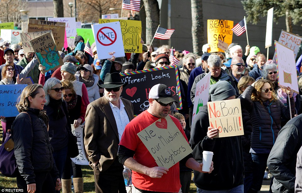 People march to voice their disapproval of President Trump in Boulder, Colorado on Saturday 