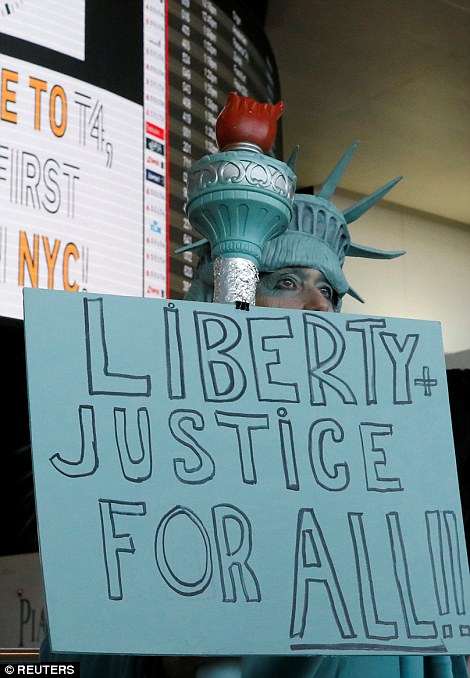 A woman holds a sign for people travelling thought JFK in New York City