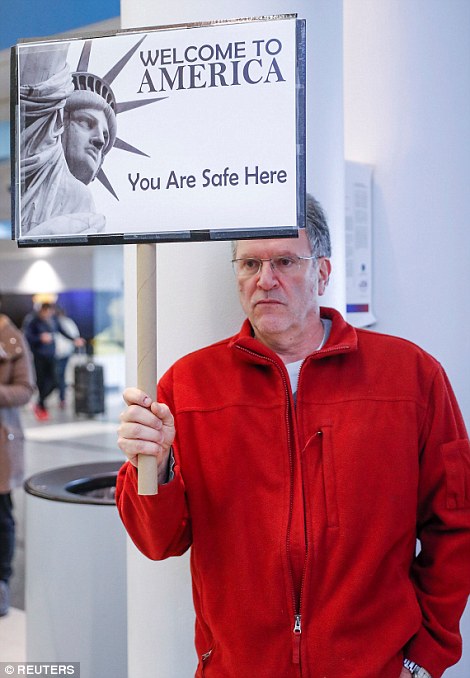 A man holds a sign at O'Hare airport in Chicago in response to the travel ban