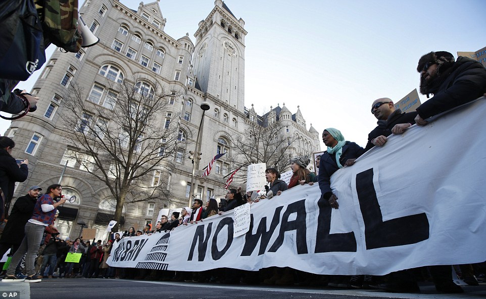 Protesters march along Pennsylvania Avenue past the Trump International Hotel during a rally on Saturday