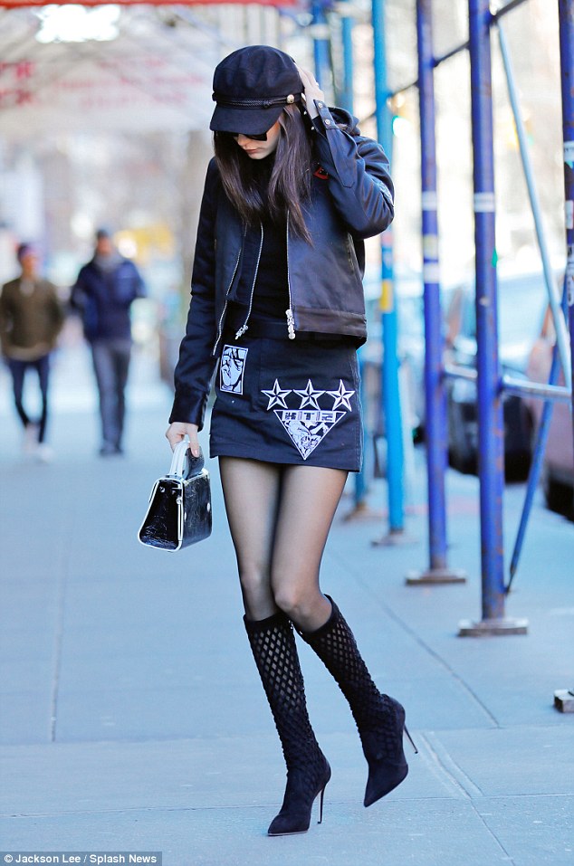 The sidewalk's a runway: The brunette looked like she'd strutted straight off the catwalk in a pageboy cap and black stiletto boots that went up nearly to the knee