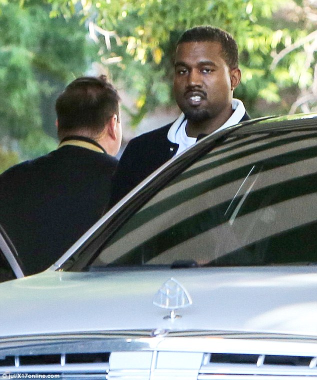 College dropout: Kanye looked cool in a black letterman jacket paired with a white tee