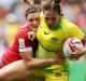 Sent packing: Evania Pelite of Australia is tackled during the semi-final loss to Canada.