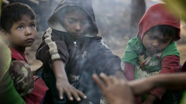 A family who fled violence in Salipara village in Myanmar, sit by a fire in the Balu Kali Rohingya refugee camp in Cox's ...