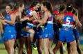 Bulldogs players celebrate their win over the Dockers on the final siren at VU Whitten Oval.