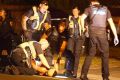 Police restrain an injured man at Springvale on Friday.