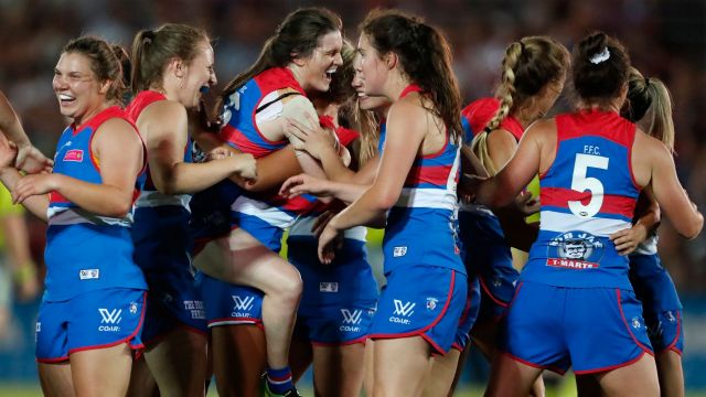 Bulldogs players celebrate their win over the Dockers on the final siren at VU Whitten Oval.