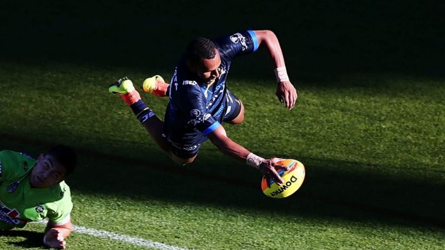 Gideon Gela-Mosby of the Cowboys scores a try against Nick Cotric of the Raiders.