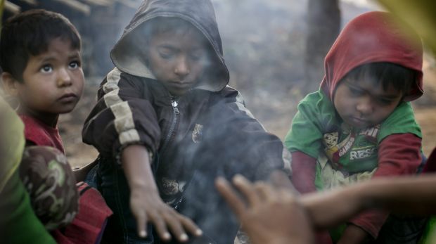 A family who fled violence in Salipara village in Myanmar, sit by a fire in the Balu Kali Rohingya refugee camp in Cox's ...