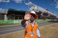 A security guard attempts to stop photographs of the buckled span on the Skytrain viaduct in Sydney's north-west.