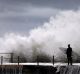 A surfer waits for a break in crashing waves before diving in for a surf off Sydney's Collaroy Beach, April 22, 2015. A ...