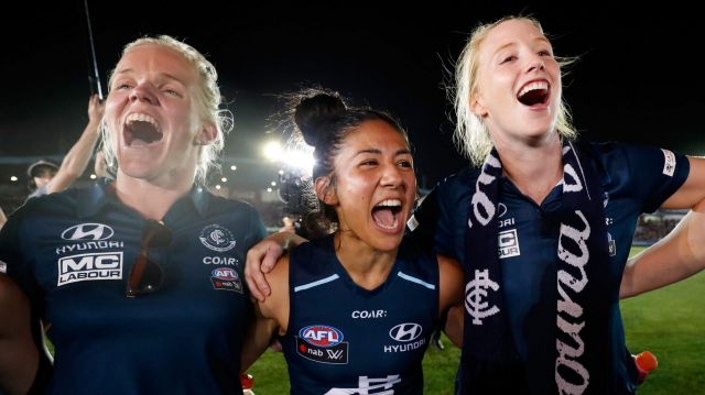 Darcy Vescio of the Blues (centre) sings the team song after the game.