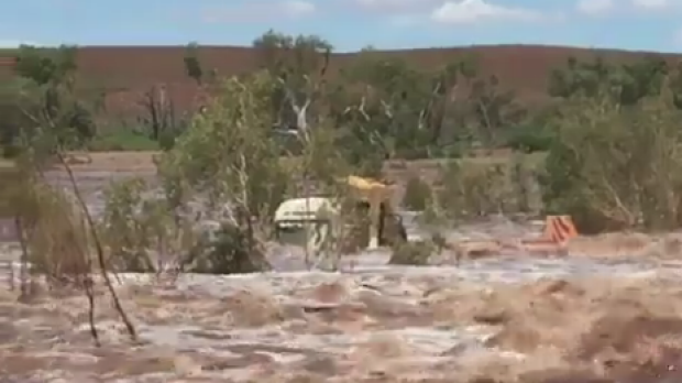 A Pilbara truck driver is lucky to be alive after his truck was swept off a road by flood waters.
