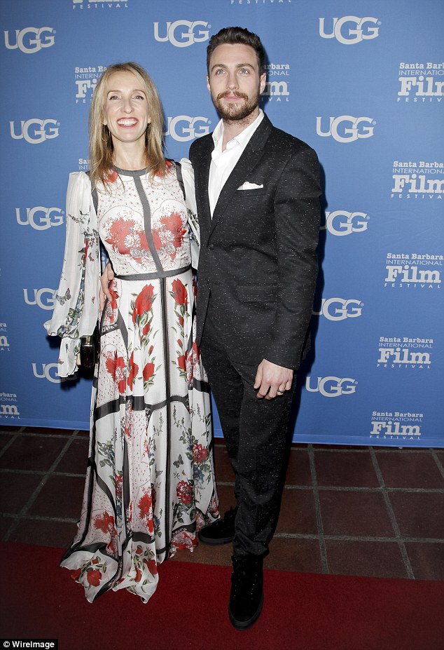 Proud: Hiding her petite frame, her boho number featured billowing sleeves as she wrapped her arm around her man on his big night