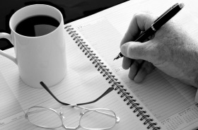 A Coffee cup, reading glasses and fountain pen.