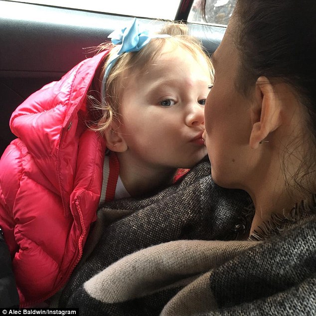 Family man: Alec Baldwin shared a sweet snap of his wife Hilaria, 33, giving their three-year-old daughter Carmen a kiss