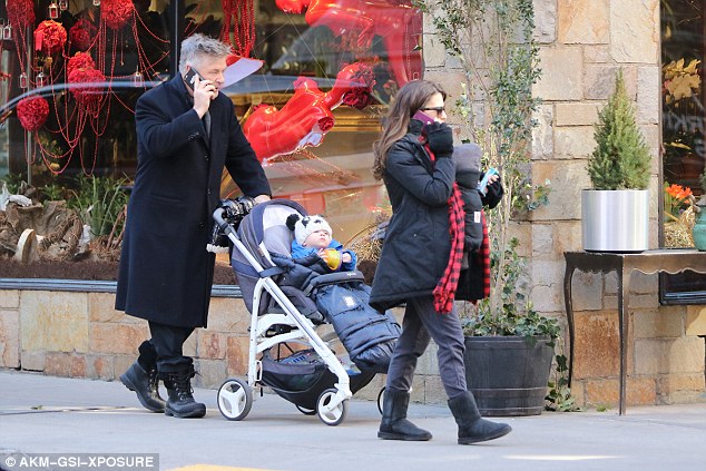 Dad on the go! Alec Baldwin multitasks as he and wife Hilaria go for a stroll in New York with children Leonardo and Rafael