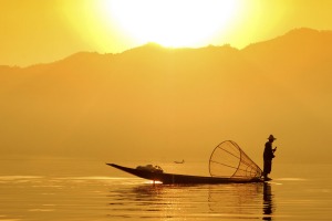 A fisherman plys his trade on Inle Lake at sunset.