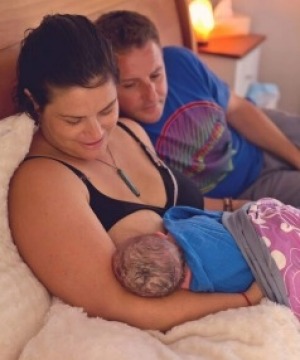 Jolene Spies breastfeeding her newborn son, Harper, in bed with husband Johann.