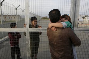 Bashir Khashan, 49, from Edlib, Syria, embraces his child after arriving at a refugees camp at Kokkinotrimithia outside of the capital Nicosia, in the eastern Mediterranean island of Cyprus, on Saturday, Feb. 4, 2017.