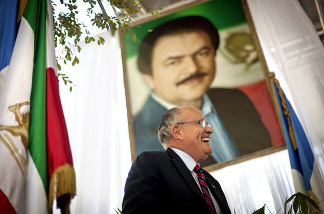 In September 2010, New York City Mayor Rudy Giuliani walks under a photo of Iran opposition leader Massoud Rajavi as he speaks at a protest of Iranian President Mahmoud Ahmadinejad's visit to the United Nations