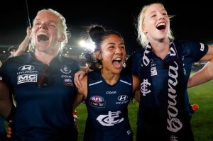 Darcy Vescio of the Blues (centre) sings the team song after the game.