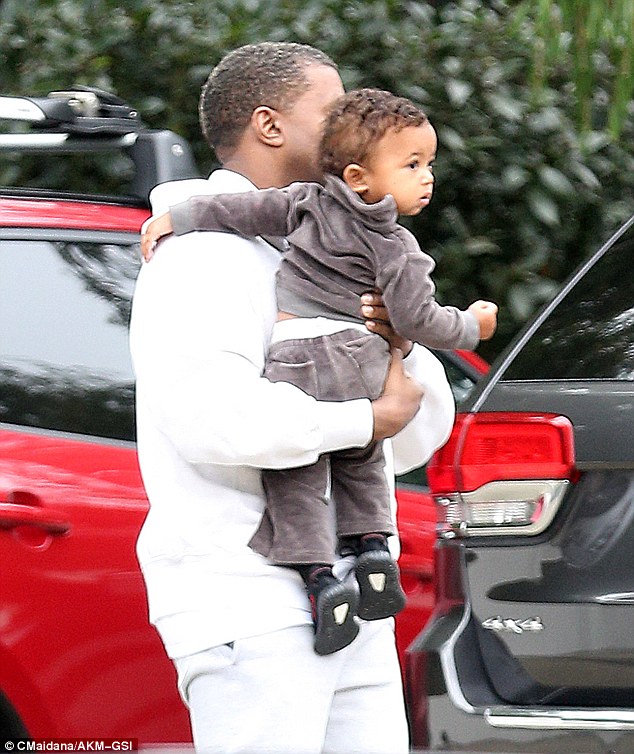 Dad's the word! Kanye West carried one-year-old Saint, who wore a mini velour tracksuit