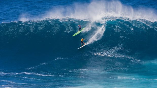 Laura Enever, upper left, and Felicity Palmateer, ride a wave at a Maui surf break known as "Jaws" in Haiku, Hawaii, on ...