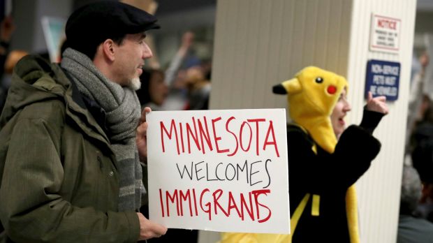 Adrian Hegeman, of St. Paul, holds a sign while joining other opponents to new immigration restrictions to protest an ...