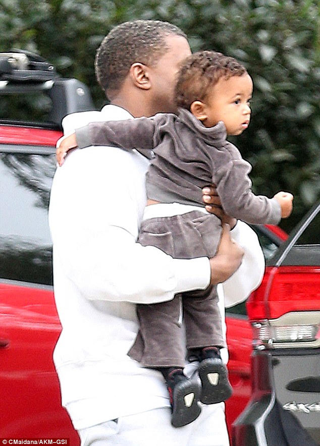 Dad's the word! Kanye West carried one-year-old Saint, who wore a mini velour tracksuit