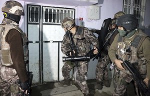 Turkish anti-terrorism police break a door during an operation to arrest people over alleged links to the Islamic State group, in Adiyaman, southeastern Turkey, early Sunday, Feb. 5, 2017.