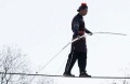 Chinese acrobats dressed in traditional costumes perform on a tightrope.