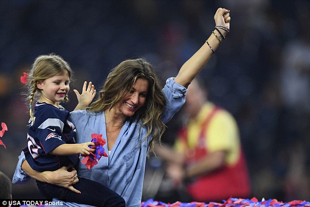 We did it: Gisele carried their only daughter as she had her other arm up in victory