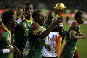 Cameroon players run celebrating with the trophy after winning the African Cup of Nations final soccer match between Egypt and Cameroon at the Stade de l'Amitie, in Libreville, Gabon, Sunday, Feb. 5, 2017. Cameroon won 2-1.