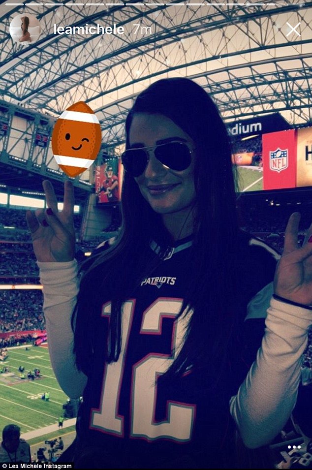 Fan-atical! She flashed the peace sign while wearing a Tom Brady jersey