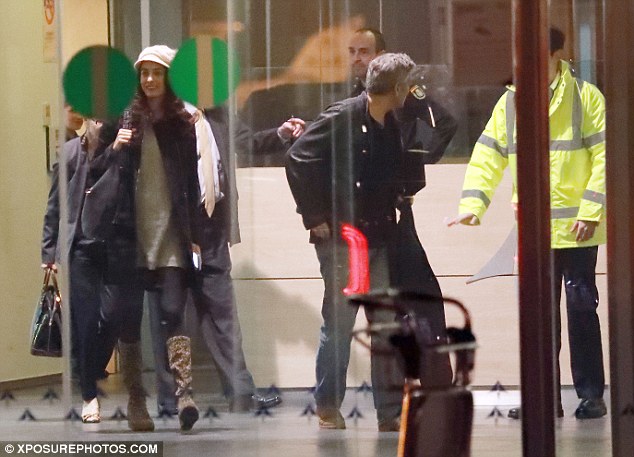 Taking charge: A dressed down George was seen chatting to airport staff before taking charge of the luggage