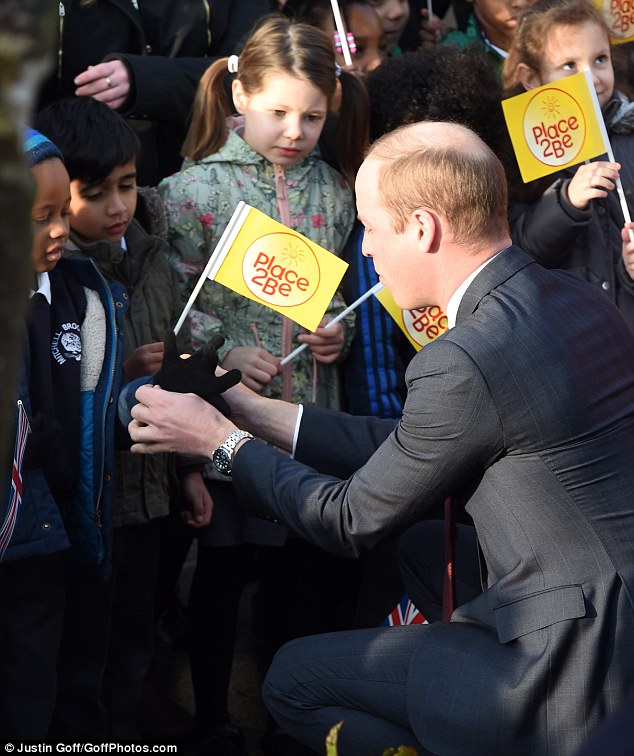 Showing his paternal side, Prince William knelt down to help a youngster put on his glove