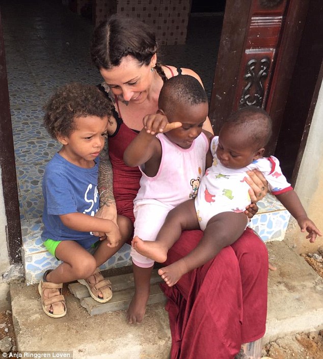 Anja, who works with a number of children in Nigeria, sits with Hope and another child on her lap