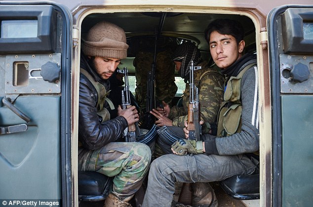 Fighters from the Free Syrian Army sit inside an armoured vehicle near the town of Bizaah