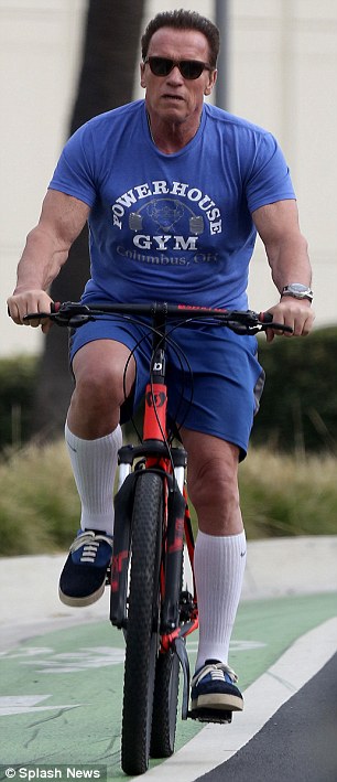 Working off the stress: Schwarnegger taking a bike ride following Trump's decision to take his personal beef with Schwarzenegger into the spotlight