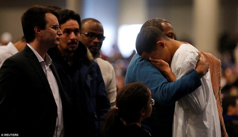 Iles Soufiane (right) is comforted by people during the funeral ceremony. One of the those laid to rest on Friday was identified as Azzedine Soufiane, 57, a Moroccan immigrant to Canada