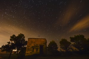 Stars seen as streaks from a long camera exposure are seen behind Arnotegui Hermitage, in Obanos, northern Spain, Tuesday, Aug. 11, 2015.