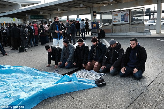 Muslim men pray at a prayer and demonstration at JFK airport to protest President Donald Trump's Executive Order on Friday 