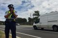 An ACT policing sergeant from Road Safety Operations checks drivers speeds on Barry Drive.